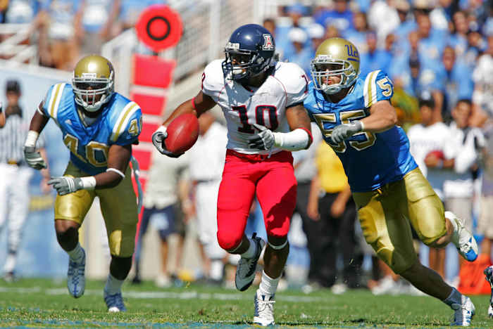 Arizona Wildcats wide receiver Mike Thomas (10) runs against the defense of UCLA Bruins guard Sonny Tevaga (55) and linebacker Akeem Ayers (40) in the second half at the Rose Bowl. Arizona defeated UCLA 31-10.